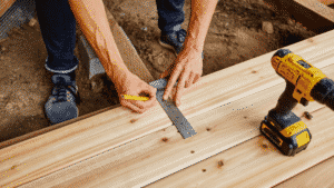 A builder makes a measurement using an L-square.