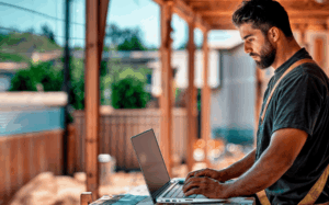 Residential builder working on a laptop on a construction site