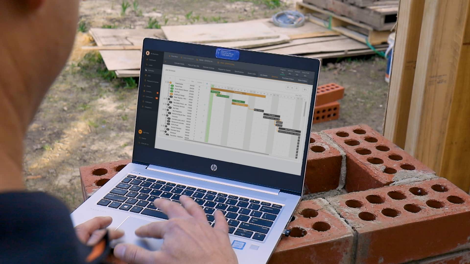 Buildxact customer updates his project schedule using a on site laptop