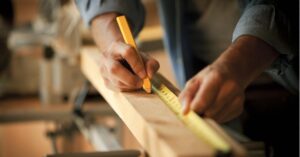A builder measuring a piece of wood