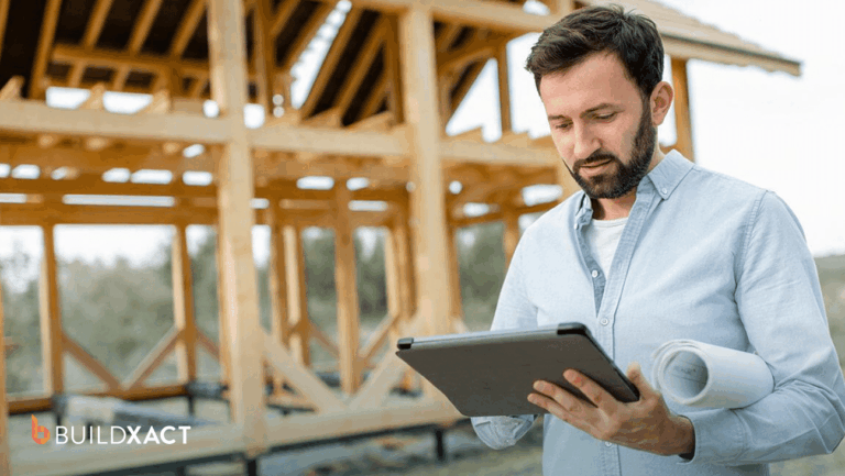Residential builder logging construction costs and hours on a tablet at an active job site