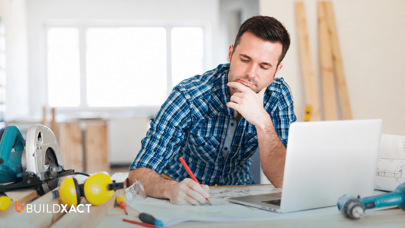 Residential builder reviewing an AI-generated construction bid on a laptop at home in the evening, checking pricing before sending it to a client