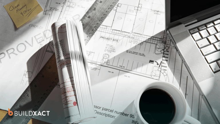 Residential estimating workspace with house plans and a laptop showing estimate line items in the evening